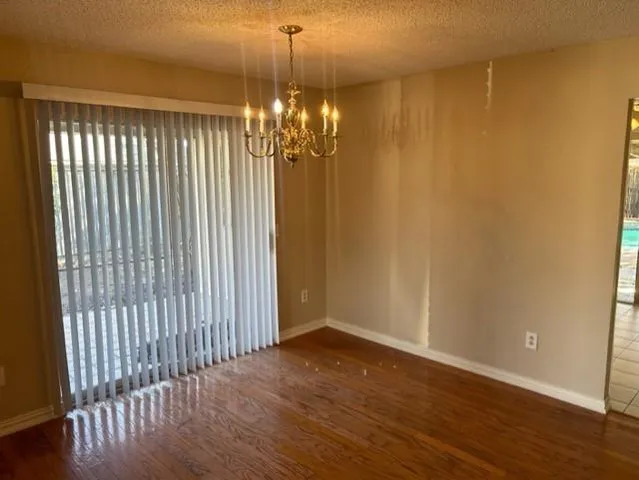 a view of a livingroom with a chandelier wooden floor and a chandelier