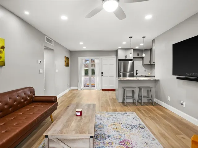 a living room with kitchen island furniture and a flat screen tv