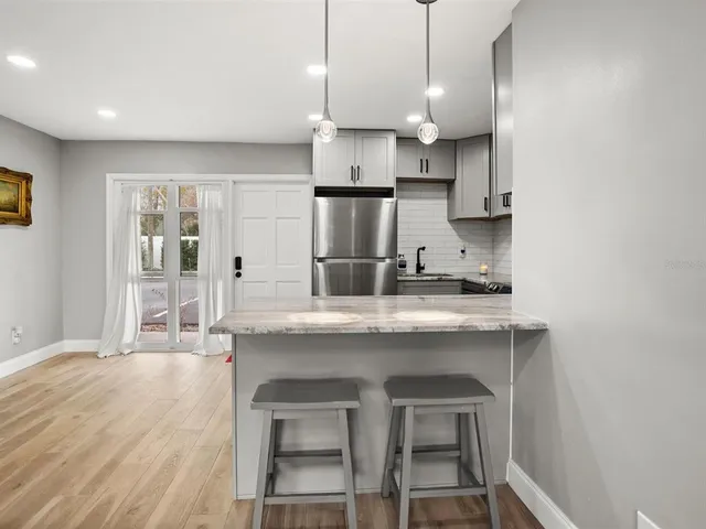 a kitchen with stainless steel appliances granite countertop a sink a stove and a wooden floors