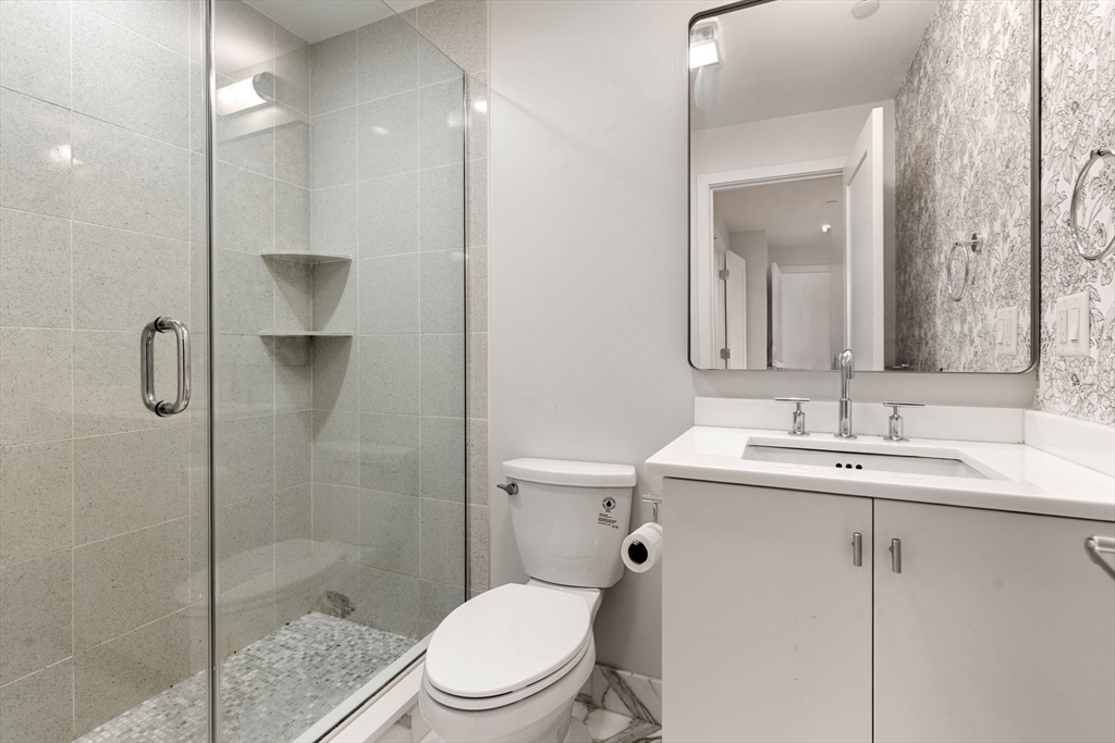242 Shawmut Avenue, Unit 1B Boston, MA 02118 - Photo 11 of 16 a bathroom with a toilet a sink a shower and mirror