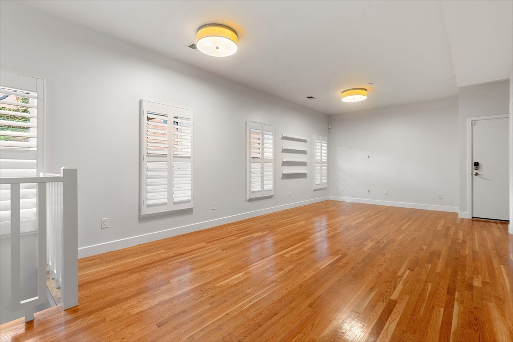 242 Shawmut Avenue, Unit 1B Boston, MA 02118 - Photo 2 of 16 an empty room with wooden floor and windows