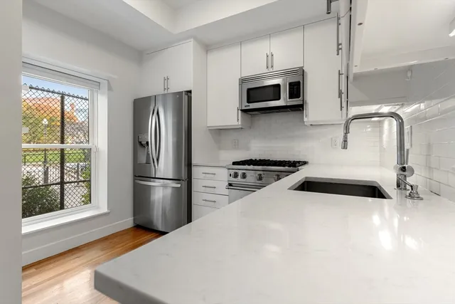 a kitchen with stainless steel appliances a microwave a sink and a refrigerator