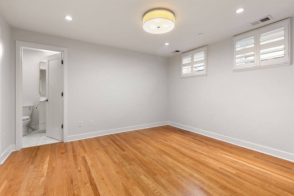 242 Shawmut Avenue, Unit 1B Boston, MA 02118 - Photo 7 of 16 an empty room with wooden floor and windows