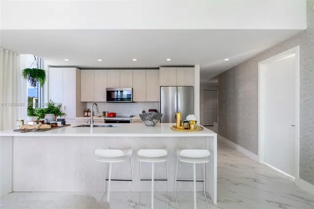 a kitchen with stainless steel appliances granite countertop a sink and a refrigerator