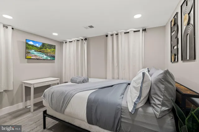 a bed sitting in a spacious bedroom next to a window