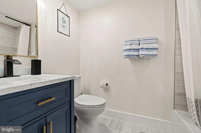 a bathroom with a granite countertop sink a toilet and a mirror