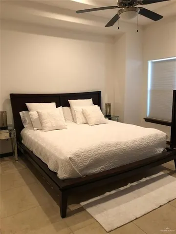 a large bed in a bedroom next to a window
