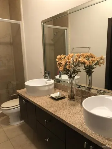 a bathroom with a granite countertop sink a toilet and mirror