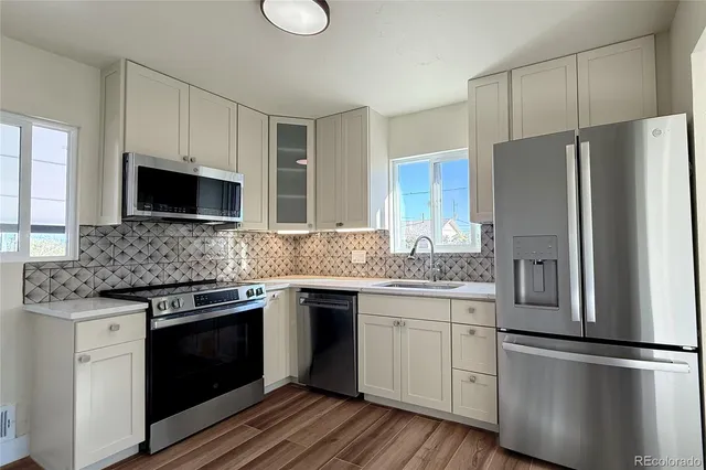 a kitchen with stainless steel appliances granite countertop a refrigerator stove a sink and dishwasher