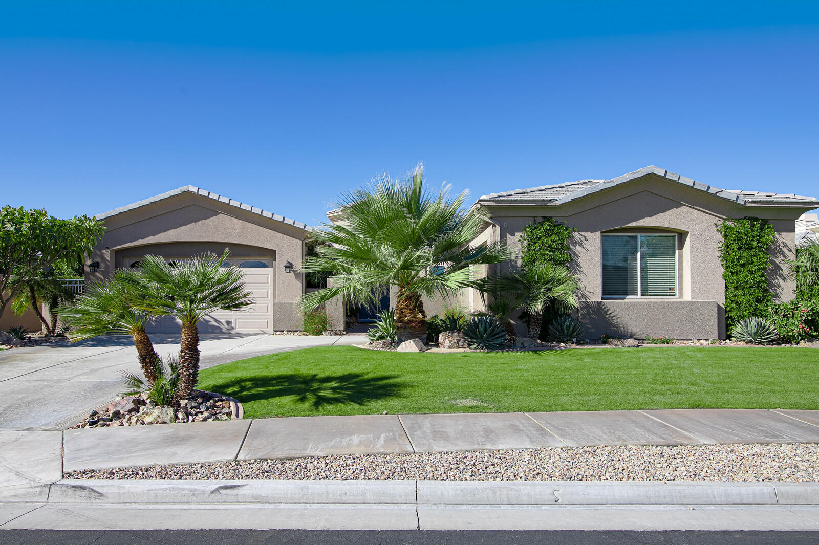 3 Lyon Road Rancho Mirage, CA 92270 - Photo 2 of 38 a front view of a house with a garden and yard