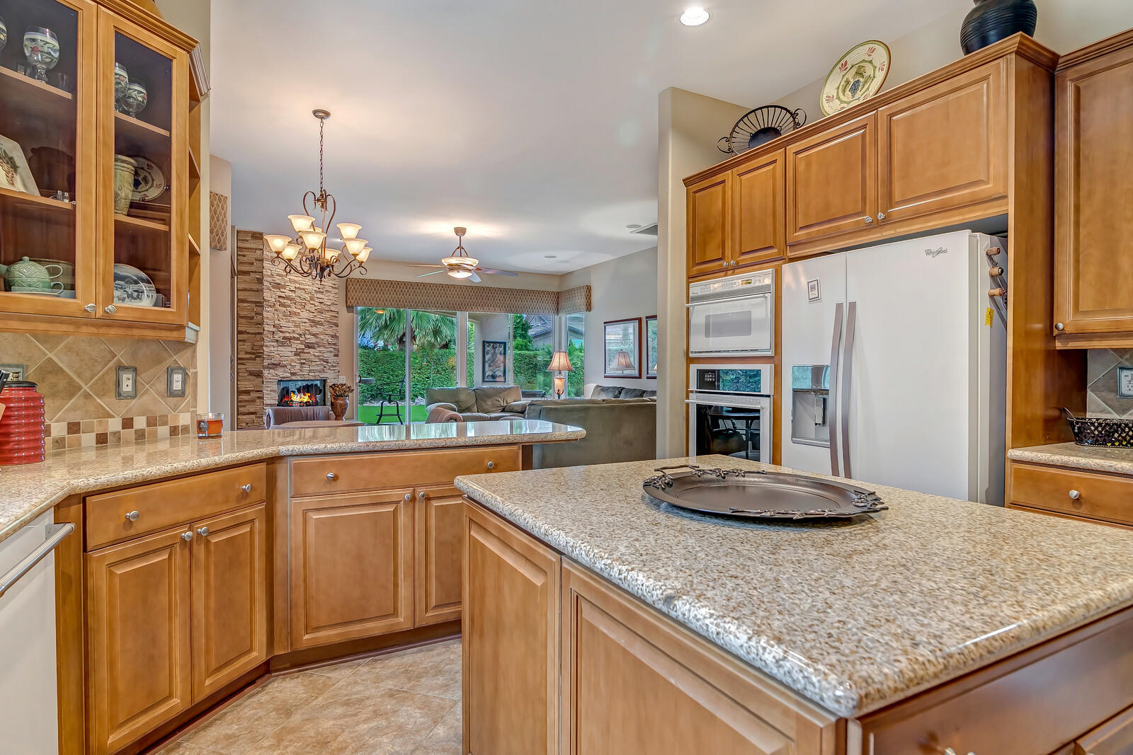 3 Lyon Road Rancho Mirage, CA 92270 - Photo 12 of 38 a kitchen with kitchen island granite countertop a sink and cabinets
