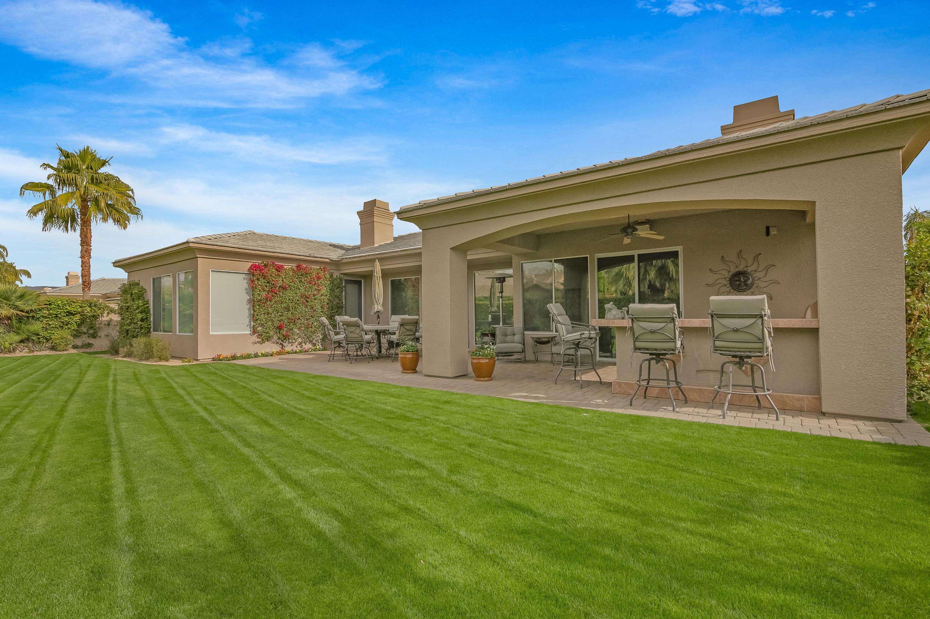 3 Lyon Road Rancho Mirage, CA 92270 - Photo 35 of 38 a porch with a table and chairs under an umbrella