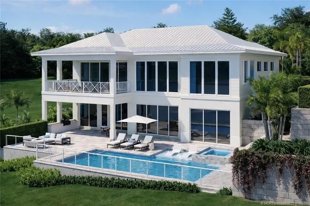 a front view of a house with swimming pool and sitting area