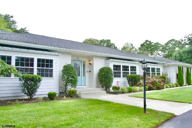 a front view of a house with a yard and plants