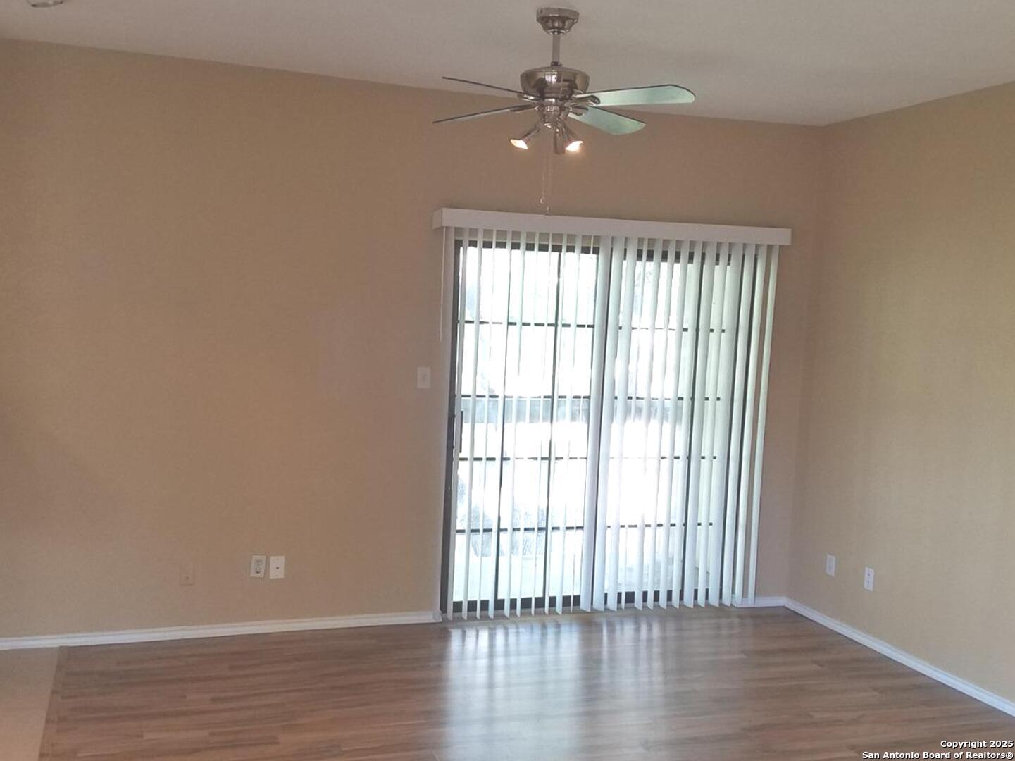 11839 Parliament Drive, Unit 1921 San Antonio, TX 78216 - Photo 6 of 19 wooden floor in an empty room with a window