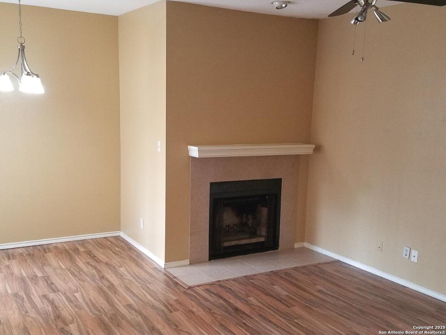 11839 Parliament Drive, Unit 1921 San Antonio, TX 78216 - Photo 7 of 19 a view of an empty room with wooden floor and a fireplace