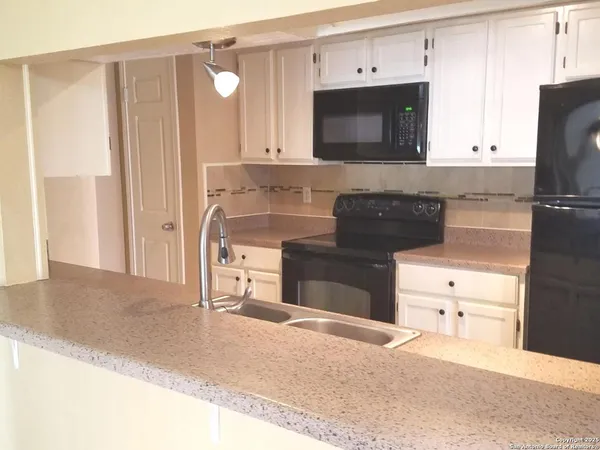 a kitchen with stainless steel appliances white cabinets and stove