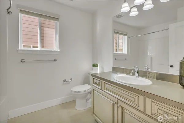 a bathroom with a granite countertop sink a toilet and a mirror