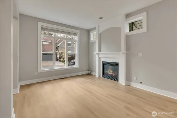 a view of an empty room with a window and fireplace