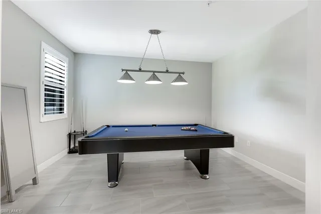 a room with pool table and window