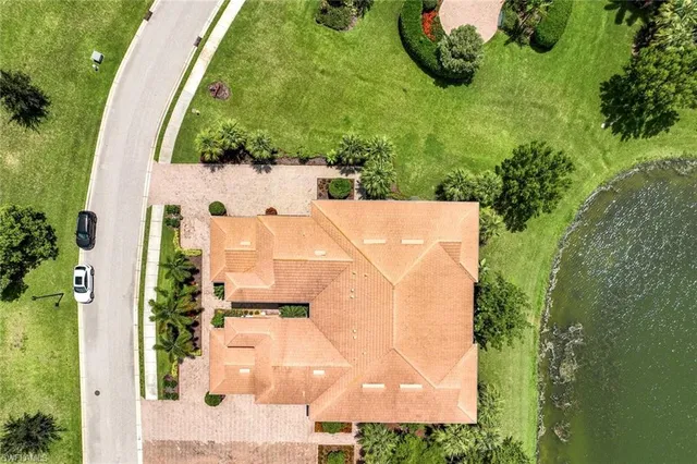 an aerial view of a house with a yard and large trees