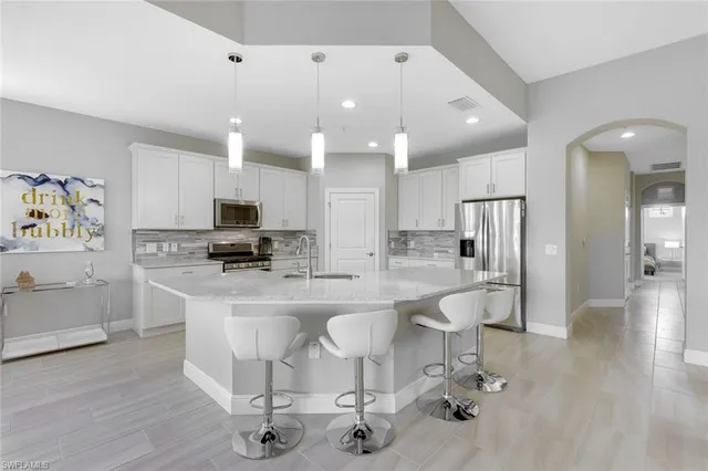 a kitchen with stainless steel appliances kitchen island granite countertop a refrigerator and cabinets