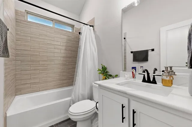 a bathroom with a sink a toilet a mirror and shower