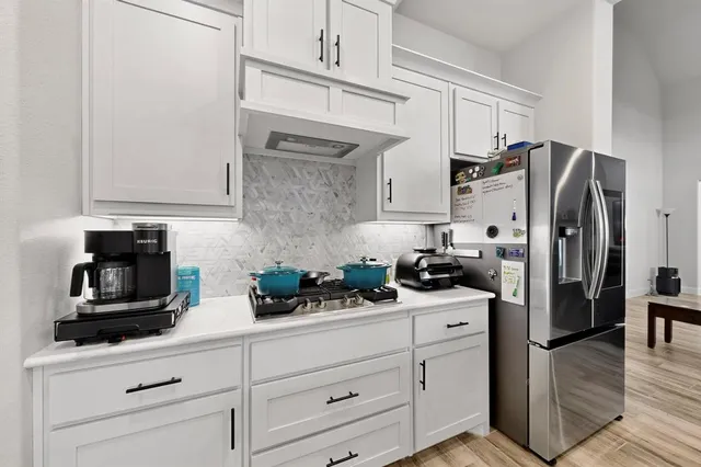 a kitchen with white cabinets and stainless steel appliances
