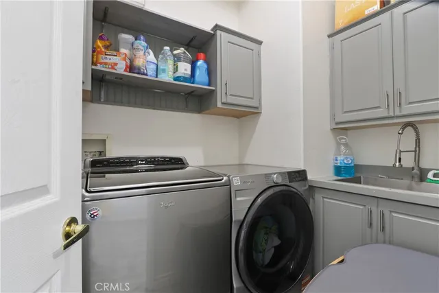 a utility room with sink dryer and washer