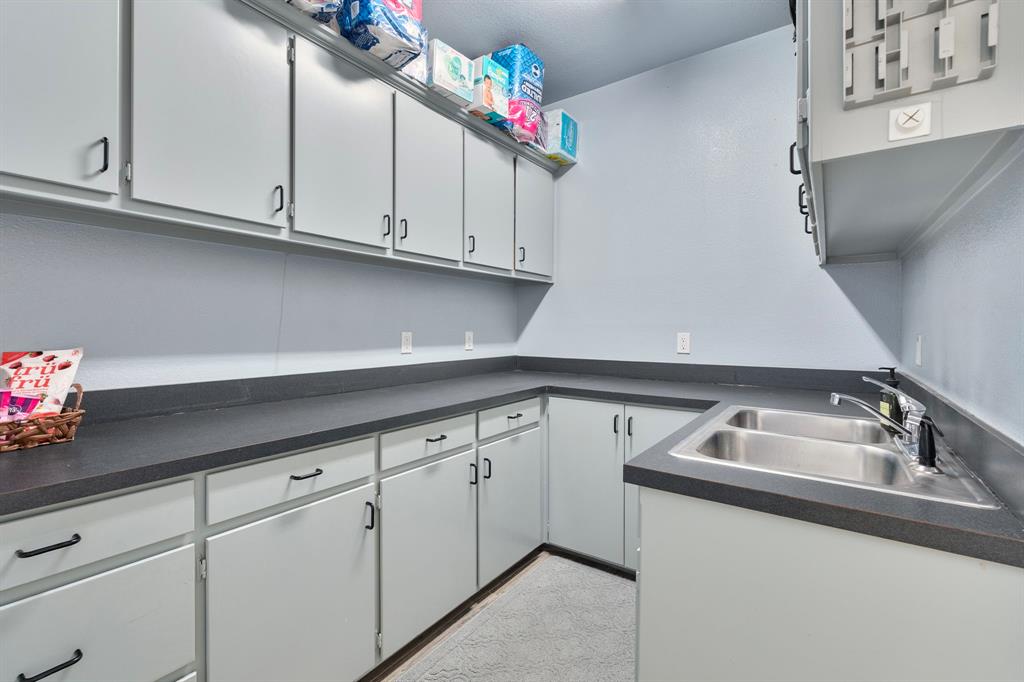 10080 Arvin Hill Road Aubrey, TX 76227 - Photo 23 of 40 a kitchen with granite countertop a sink dishwasher and cabinets with wooden floor