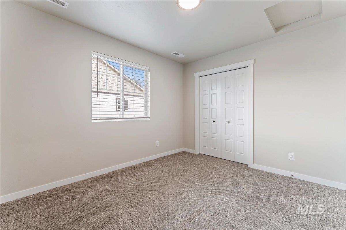 2501 East Goldstone Street Meridian, ID 83642 - Photo 12 of 26 Unfurnished bedroom with light colored carpet and a closet