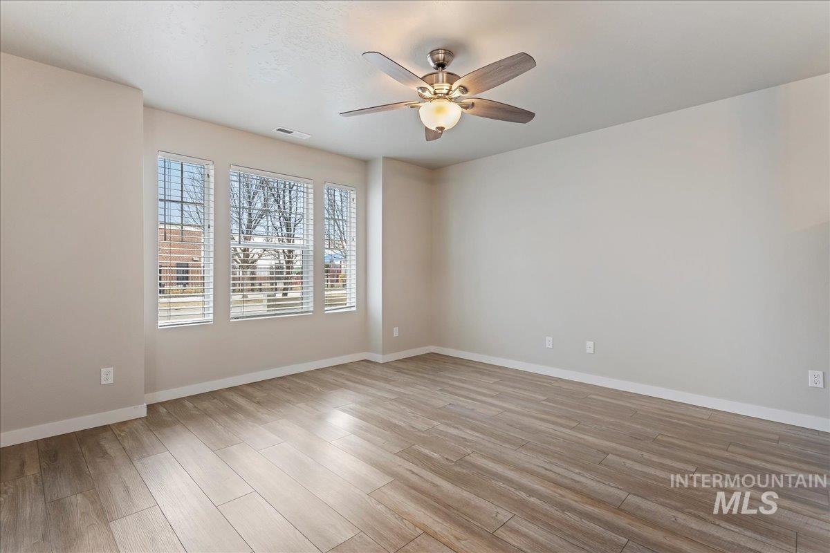 2501 East Goldstone Street Meridian, ID 83642 - Photo 4 of 26 Empty room featuring a ceiling fan and light wood-type flooring