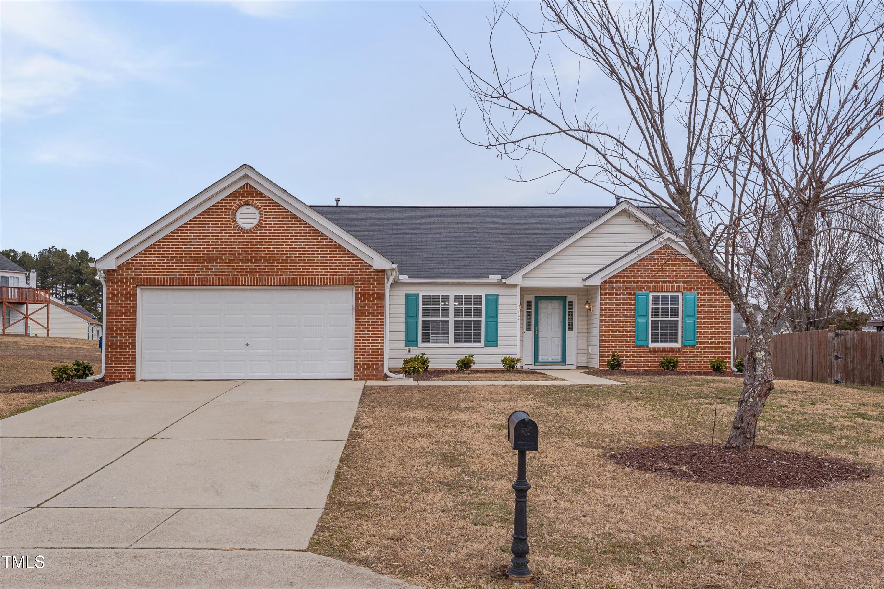 3217 Flowery Branch Road Raleigh, NC 27610 - Photo 1 of 12 a front view of a house with a yard and garage