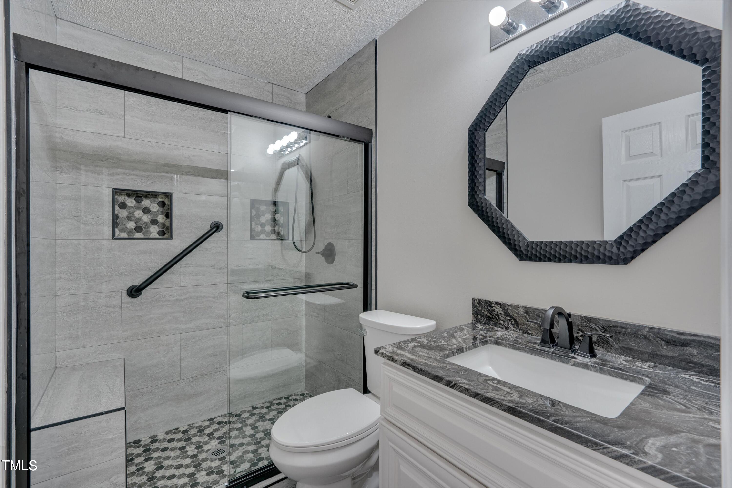 3217 Flowery Branch Road Raleigh, NC 27610 - Photo 8 of 12 a bathroom with a granite countertop sink mirror vanity and toilet