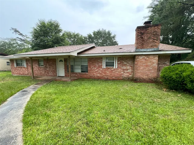 a view of a house with a yard and potted plants
