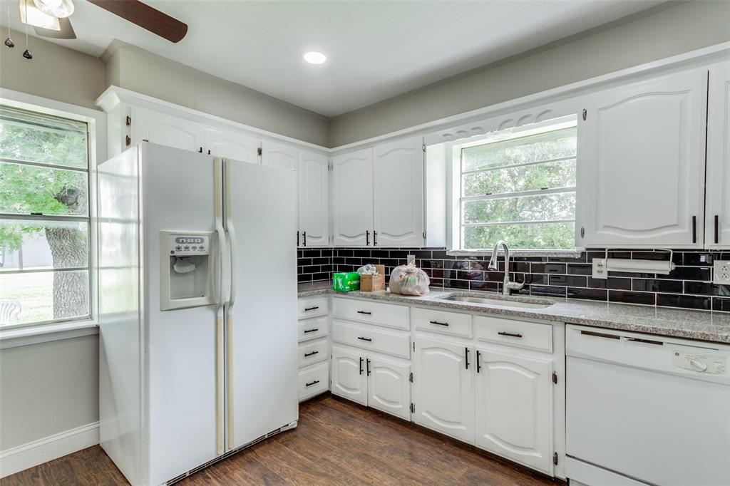 925 West Lucas Road Lucas, TX 75002 - Photo 11 of 23 a kitchen with stainless steel appliances white cabinets and wooden floors