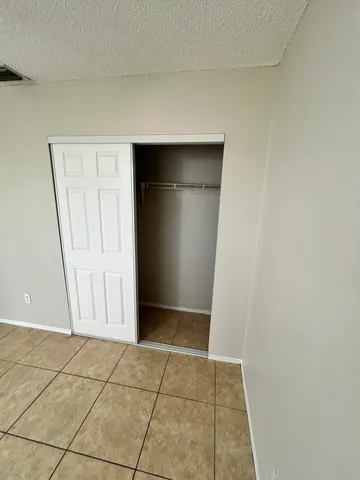 an empty room with walk in closet with white walls