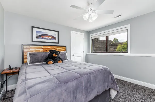 a bedroom with bed and paintings on the wall
