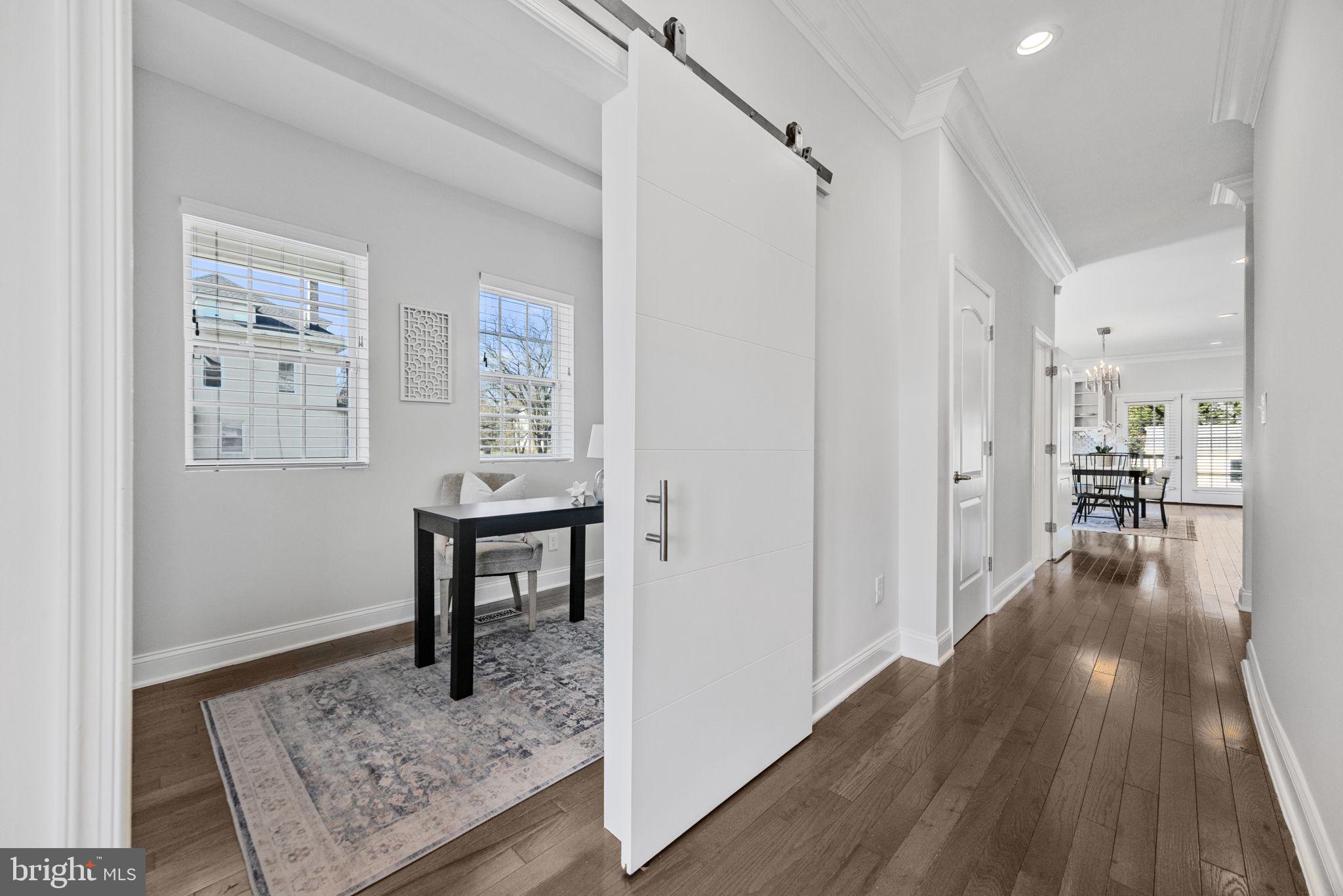 2420 West Rogers Avenue Baltimore, MD 21209 - Photo 22 of 67 a view of a hallway that has a couch and a dining table with wooden floor