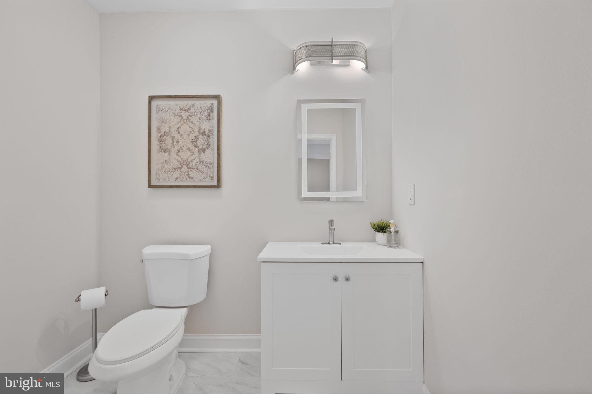 2420 West Rogers Avenue Baltimore, MD 21209 - Photo 23 of 67 a bathroom with a toilet a sink and mirror