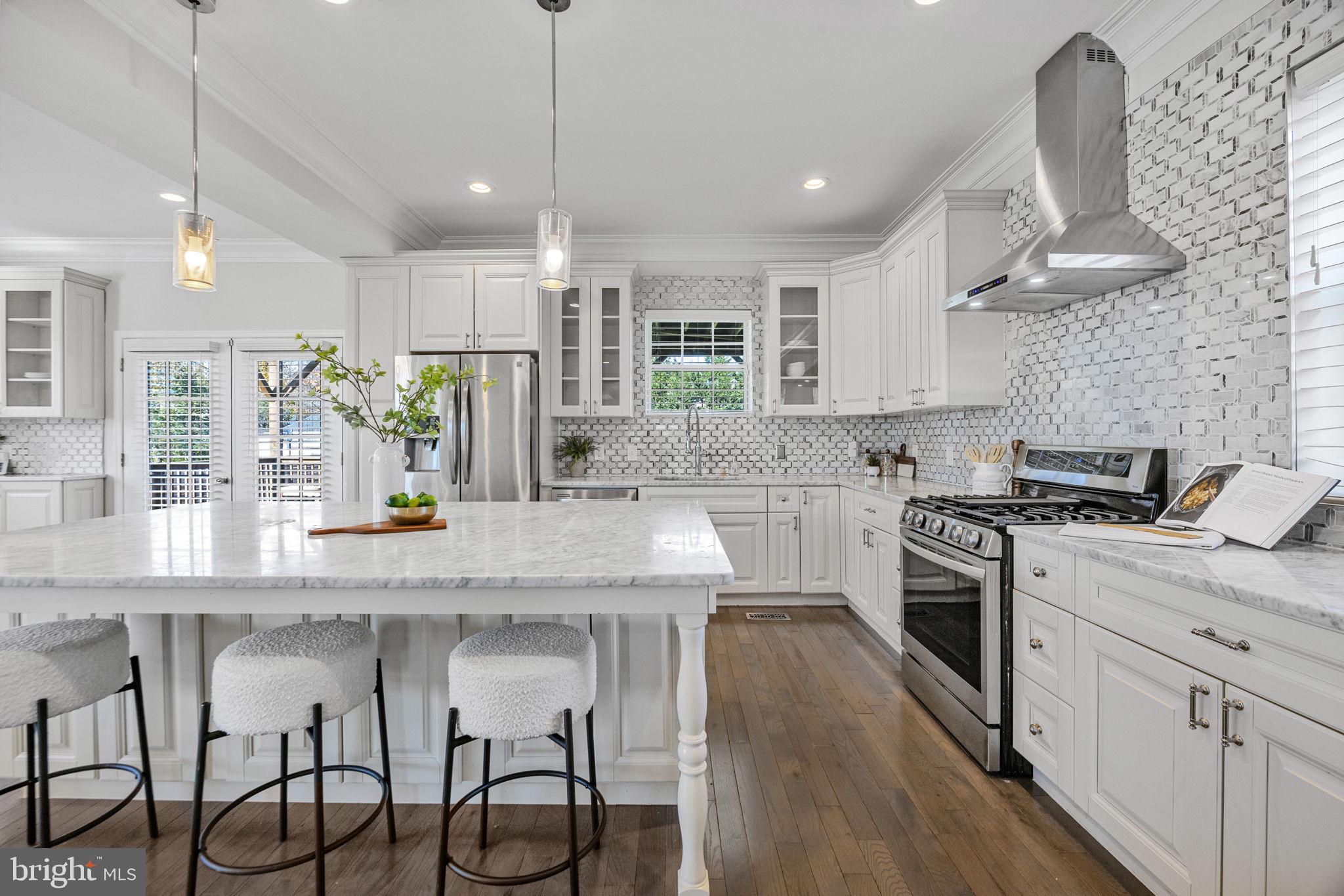 2420 West Rogers Avenue Baltimore, MD 21209 - Photo 5 of 67 a kitchen with stainless steel appliances granite countertop a stove a sink a oven a dining table and chairs with wooden floor