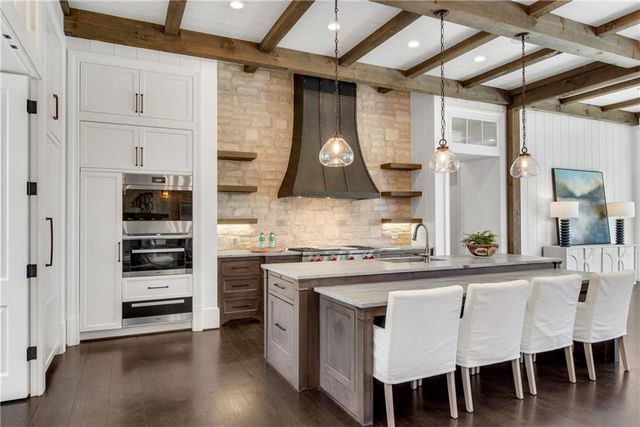 a kitchen with stainless steel appliances granite countertop a stove and cabinets