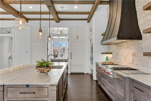 a kitchen with stainless steel appliances a sink a stove and a refrigerator