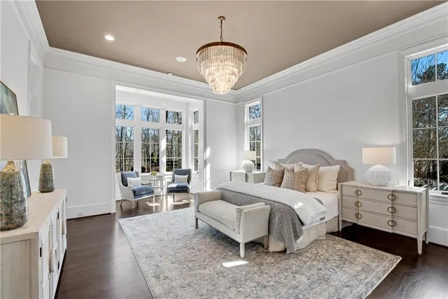 a bedroom with a large bed and a chandelier