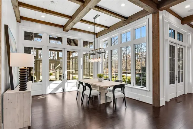 a dining room with wooden floor glass table and chairs