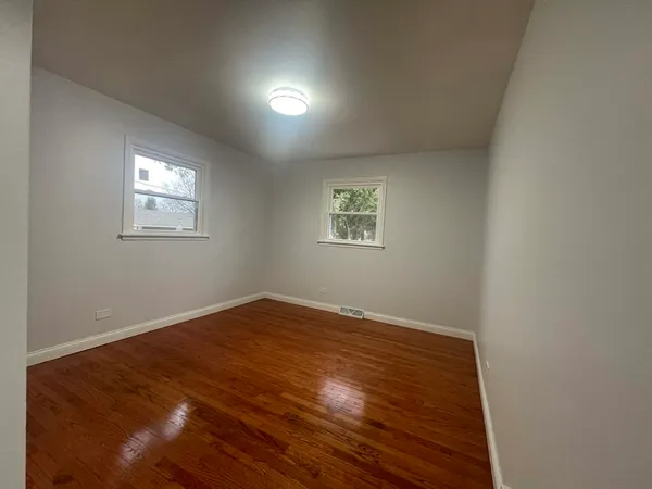 a view of a room with wooden floor and windows