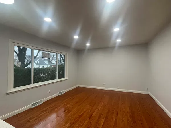 a view of an empty room with wooden floor