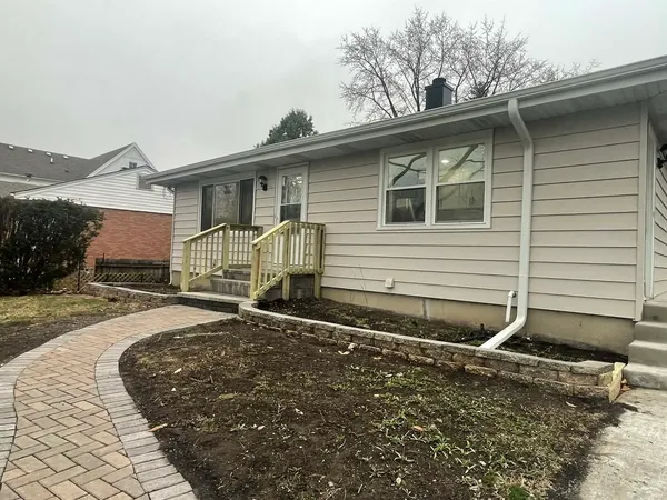 a front view of a house with a yard and trees