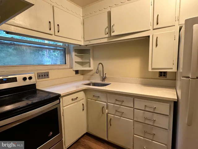 a view of a kitchen with cabinets appliances and a ceiling fan