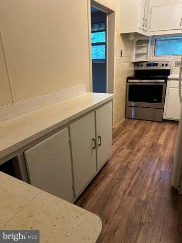 a kitchen view with wooden floor and electronic appliances